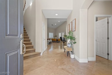 Entryway featuring stairway, a towering ceiling, and recessed lighting