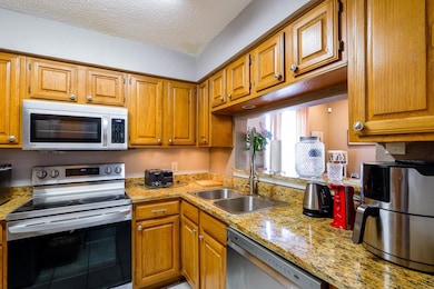 Kitchen with wood stained cabinets, appliances wit