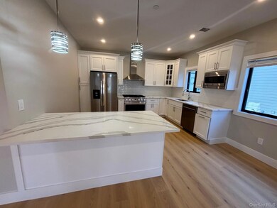 Kitchen featuring glass insert cabinets, white cabinets, appliances with stainless steel finishes, tasteful backsplash, and recessed lighting