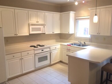 Large, white kitchen with breakfast bar.