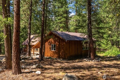 The home sits within a forested setting of mature trees and openings that together bathe the property in dappled sunlight.