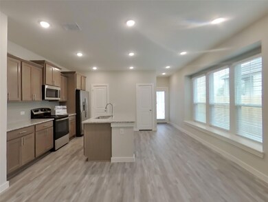 Kitchen with stainless steel appliances, light wo