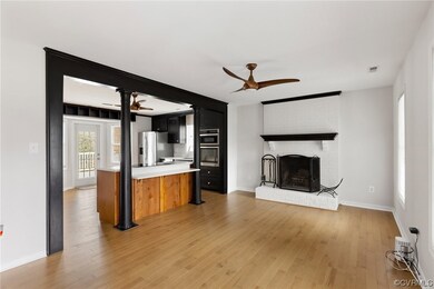Kitchen with brick wall, a fireplace, light hardwo