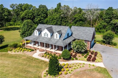 Covered front porch, concrete walkway, double garage & beautiful landscaping