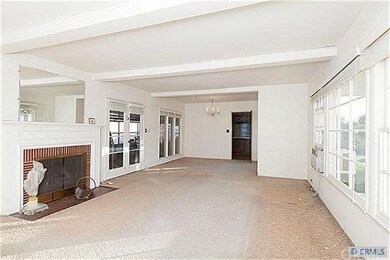 Living room with brick fireplace and beamed ceilin