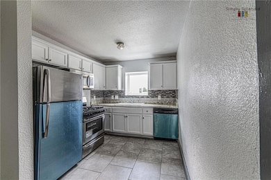 Kitchen with stainless steel appliances, a textur
