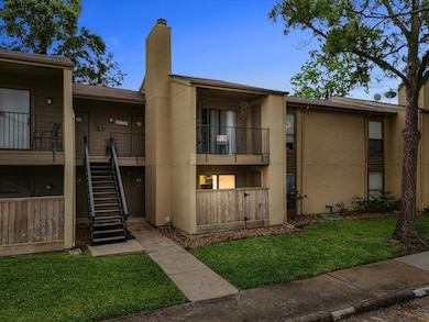 Discover the charm of this inviting condo with a cozy downstairs patio, nestled in a serene setting with lush greenery.