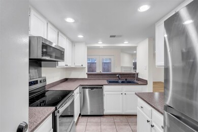 Kitchen featuring french doors, white cabinets, si