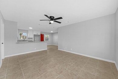 An open floor plan features continuous tile flooring, joining each area seamlessly.