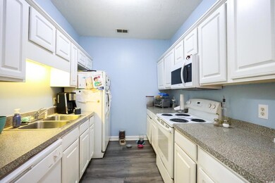 Kitchen with dark hardwood / wood-style floors, si