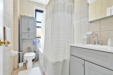 Bathroom with tile walls, tile patterned floors, vanity, and shower / bath combo with shower curtain
