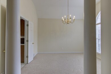 Unfurnished room with high vaulted ceiling, a nota
