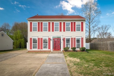 Colonial home with fence, concrete driveway, and a