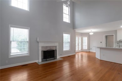 Unfurnished living room featuring a high ceiling, a ceiling fan, a premium fireplace, and healthy amount of natural light