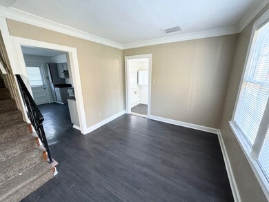 Spare room featuring crown molding and dark hardwo