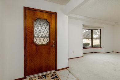 Entrance foyer with a textured ceiling, light tile