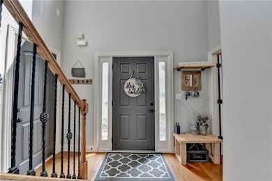 Foyer entrance featuring light wood-style flooring, a high ceiling, and stairs
