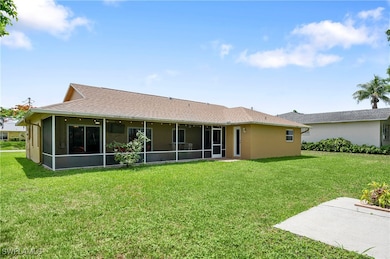 Rear view of property with a sunroom, a yard, and