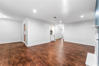 Unfurnished living room with baseboards, dark wood-style floors, recessed lighting, and a fireplace