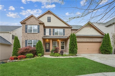Craftsman-style house with concrete driveway, a front yard, a garage, and brick siding