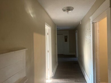 Hallway featuring a textured ceiling and dark wood