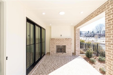 The covered patio features a brick fireplace and a slider door that opens to a spacious media room - making this the ultimate entertaining space.