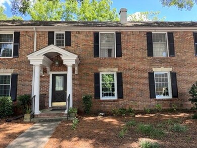 View of front facade featuring brick siding and a chimney