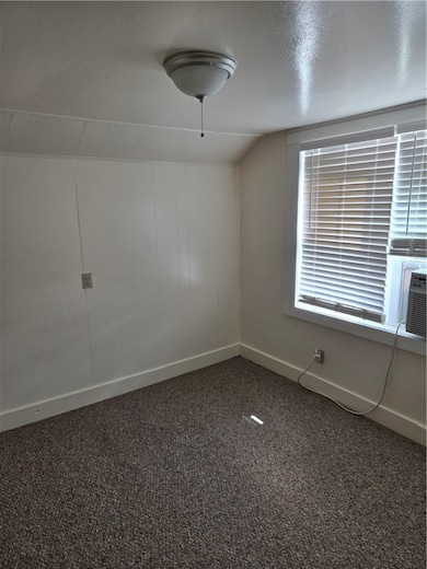 Unfurnished room with carpet, baseboards, and loft