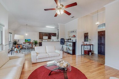 Living room featuring ornamental molding, light wo