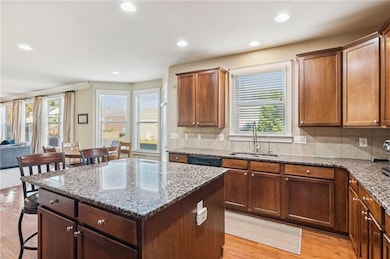Find ample counter space around the sink, with a window overlooking the backyard and tile backsplash for easy cleaning. The thoughtful design includes a breakfast area with views.
