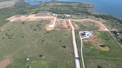 Aerial view of property and surrounding area featuring Lake Ray Roberts