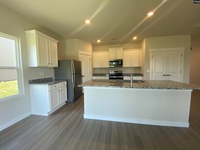 The kitchen features granite countertops and a full suite of stainless steel appliances.