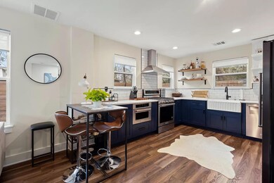 Kitchen featuring wall chimney exhaust hood, stai