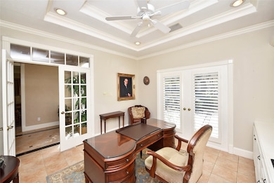 Just to the left of the entryway is the study.  A double tray ceiling with crown molding, ceiling fan and recessed light are features in this stately office.  The French doors with transom window lend a bit of added privacy without feeling secluded.