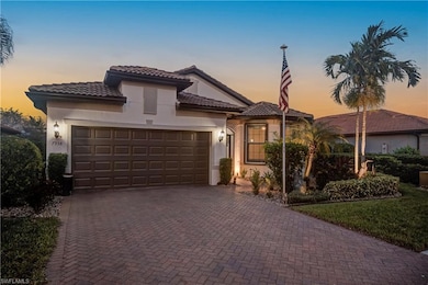 Mediterranean style home featuring stucco siding, lush landscaping, lighting, decorative driveway, a tiled roof, and a 2+garage on a premium water lot