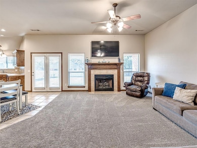 Living area with fireplace is spacious and has patio access. Living room is open to the dining room/kitchen area too.