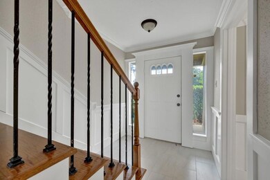 Foyer entrance featuring stairs, ornamental moldi