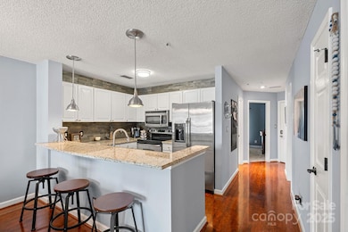 Eat-in kitchen with granite countertops and stainless appliances, adjacent to pantry and laundry room.