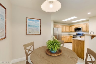 Dining space with light tile patterned floors, bas