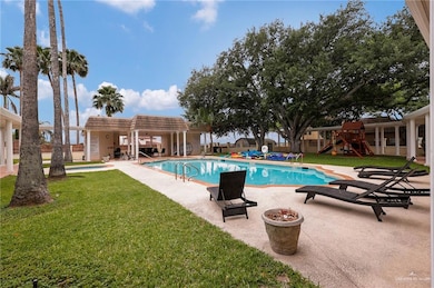Community pool featuring a yard, a patio, fence, and playground community