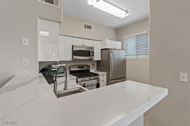 Kitchen with visible vents, white cabinetry, a pen