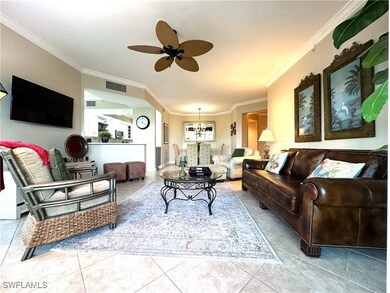 Living room with ornamental molding, tile floors,