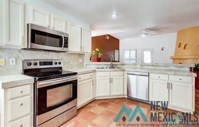 Kitchen with stainless steel appliances, light countertops, decorative backsplash, and white cabinets