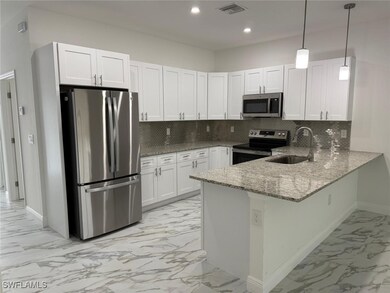Kitchen with stainless steel appliances, a sink, l