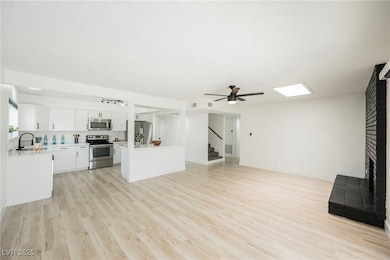 Unfurnished living room featuring stairs, light wo