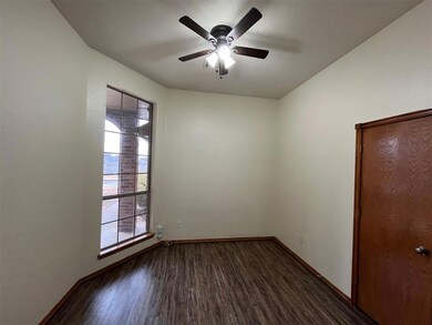 Unfurnished room featuring ceiling fan and dark ha
