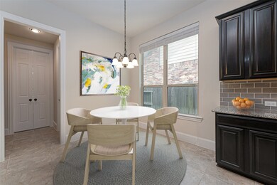 Enjoy a meal with the family in this lovely breakfast area, featuring a gorgeous chandelier, lovely tile floors, and plenty of natural light through the large window with privacy blinds!