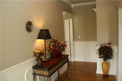 Foyer - Features wood flooring, crown molding and wainscoting.