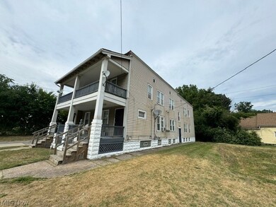 View of home's exterior featuring a balcony, covered porch, and a yard