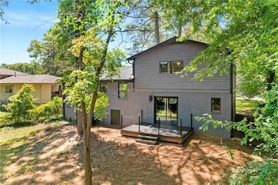 Back of house featuring a deck and brick siding